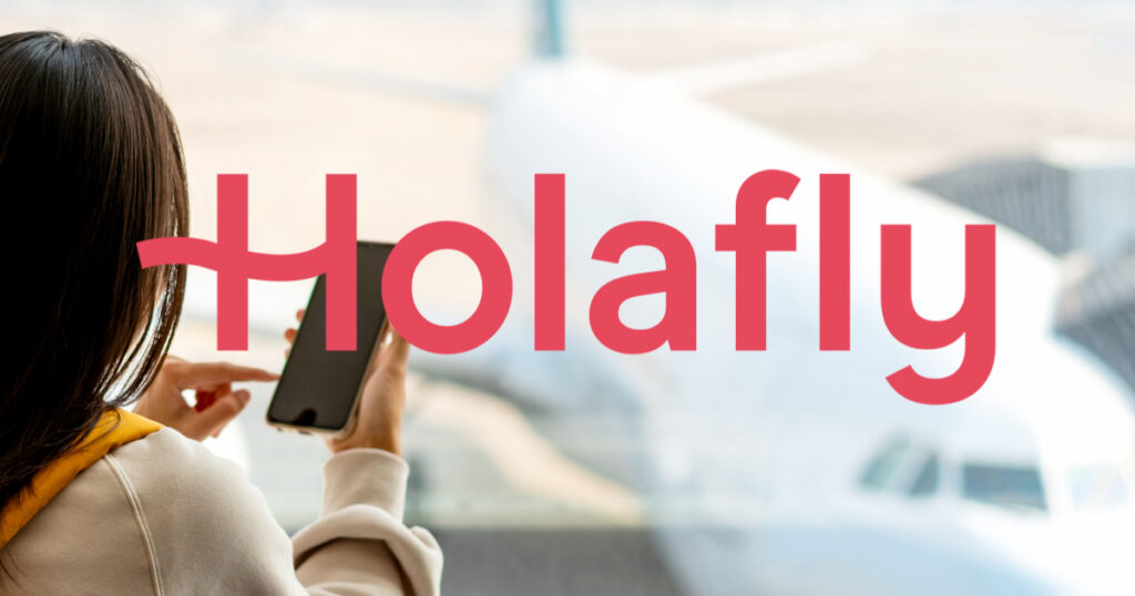 Woman using phone at the airport with Holafly eSIM